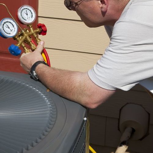 A Technician Tests an Air Conditioner.