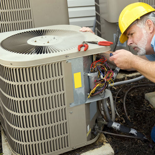 A Technician Checks the Wiring on An Air Conditioner.