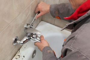 Plumber conducts faucet repair