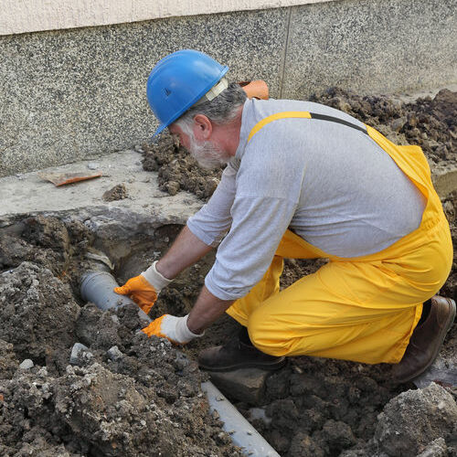 Worker Finishing Sewer Line Repair