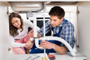A plumber offers his plumbing services to a home owner.